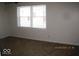 Bright bedroom featuring neutral carpet, a large window, and fresh white paint at 3008 W Grace Ln, Muncie, IN 47304