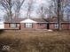 Charming single-story brick home featuring black shutters and freshly mulched landscaping at 3008 W Grace Ln, Muncie, IN 47304