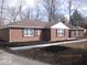 Angle view of a cozy brick home with fresh mulch landscaping and a well-maintained lawn at 3008 W Grace Ln, Muncie, IN 47304