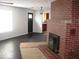 Living room featuring a brick fireplace, dark wood floor, and modern lighting at 3008 W Grace Ln, Muncie, IN 47304