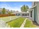 Charming backyard featuring a white picket fence, green grass, and a sunroom, perfect for relaxing outdoors at 315 W High St, Pendleton, IN 46064