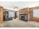 Cozy living room featuring a brick fireplace, wood paneling, and ceiling fan at 315 W High St, Pendleton, IN 46064