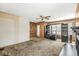 Carpeted living room featuring wood paneled walls and a ceiling fan at 315 W High St, Pendleton, IN 46064