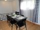 Inviting dining area featuring a black table set with checkered placemats under natural lighting from nearby windows at 3426 Ireland Dr, Indianapolis, IN 46235