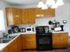 Kitchen featuring wood cabinets, white countertops, and black appliances at 3426 Ireland Dr, Indianapolis, IN 46235