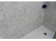 Close-up of a shower with gray marble-like walls and a white shower base, accented with a purple bath puff at 3426 Ireland Dr, Indianapolis, IN 46235