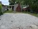 View of gravel backyard featuring a covered patio and lawn area at 357 N 18Th Ave, Beech Grove, IN 46107