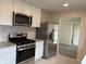 Modern kitchen with stainless steel appliances, granite counters, and white cabinets at 357 N 18Th Ave, Beech Grove, IN 46107