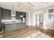 Open-concept kitchen with island, gray cabinets, and stainless steel appliances near the foyer at 401 Jersey St, Westfield, IN 46074