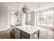 Kitchen island with stainless steel appliances and pendant lighting adjacent to dining area at 401 Jersey St, Westfield, IN 46074