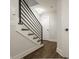 Modern staircase with dark metal railing and wood treads leads to the upper level, complemented by neutral walls and wood-look floors at 401 Jersey St, Westfield, IN 46074