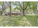 Large, grassy backyard with mature trees and a brick house, great for outdoor activities at 4050 Westover Dr, Indianapolis, IN 46268