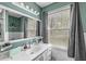 Bright bathroom features a white vanity, large mirror, and a window providing natural light at 4050 Westover Dr, Indianapolis, IN 46268