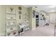 Open-concept hallway boasts white ladder shelves, decor, leading to the kitchen with white cabinets and modern appliances at 4050 Westover Dr, Indianapolis, IN 46268