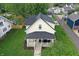 Overhead shot of a charming home with a front porch, lush lawn, and nearby outbuilding at 410 E North St, Greenfield, IN 46140