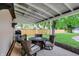 Relaxing covered porch with patio furniture, grill, and view of backyard lawn at 410 E North St, Greenfield, IN 46140