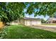 Spacious backyard featuring a detached garage and shed, surrounded by lush greenery and a well-maintained lawn at 410 E North St, Greenfield, IN 46140
