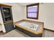 Bathroom featuring a soaking tub, tiled surround, and built in storage at 410 E North St, Greenfield, IN 46140