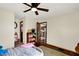 Spacious bedroom with hardwood floors, a ceiling fan, and open doorways to the kitchen and hall at 410 E North St, Greenfield, IN 46140