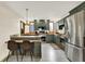 A wide kitchen shot showing the stainless appliances, dark green cabinets, and breakfast bar at 410 E North St, Greenfield, IN 46140