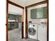 Bright laundry room features modern washer and dryer, cabinets, and access to the updated kitchen at 410 E North St, Greenfield, IN 46140