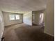 View of the living room with brown carpet, textured ceilings and two windows allowing natural light at 4109 East 21St St, Indianapolis, IN 46218