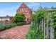 Charming brick home featuring a lovely patio area, complete with lush landscaping and a wooden fence at 419 N College Ave, Indianapolis, IN 46202