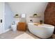 Modern bathroom featuring soaking tub, toilet, accent wall, and unique wooden storage unit at 419 N College Ave, Indianapolis, IN 46202