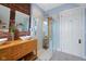 Modern bathroom featuring double sinks, exposed brick, and a glass enclosed shower with a wood accent at 419 N College Ave, Indianapolis, IN 46202