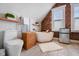Modern bathroom with soaking tub, exposed brick, tile floors, mini fridge, and a unique wooden storage unit at 419 N College Ave, Indianapolis, IN 46202