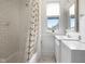 All-white bathroom with subway tile, patterned shower curtain, and vintage mirror at 419 N College Ave, Indianapolis, IN 46202