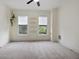 Bright bedroom with neutral walls and carpet, featuring two windows and traditional trim at 419 N College Ave, Indianapolis, IN 46202