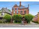 Charming red-brick two-story home with mature landscaping, front porch, and classic architectural details at 419 N College Ave, Indianapolis, IN 46202