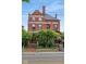 Classic red-brick home with symmetrical facade, large windows, mature trees, and inviting curb appeal at 419 N College Ave, Indianapolis, IN 46202