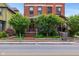 Brick home featuring an inviting entrance framed by mature trees, sidewalk, and charming front porch at 419 N College Ave, Indianapolis, IN 46202