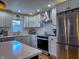 Well-lit kitchen with stainless steel appliances, white cabinetry, quartz countertops, and hardwood floors at 4284 E County Road 100 S, Avon, IN 46123