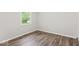 This is a clean bedroom that features wood-look flooring and a bright window at 4432 Brittany Rd, Indianapolis, IN 46222