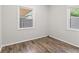 Modest bedroom featuring wood-look floors and two windows offering natural light at 4432 Brittany Rd, Indianapolis, IN 46222