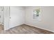 A clean bedroom features wood-look flooring, sliding door closet, and a window at 4432 Brittany Rd, Indianapolis, IN 46222