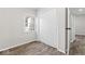 Bedroom with wood-look flooring, window, and closet with sliding doors at 4432 Brittany Rd, Indianapolis, IN 46222