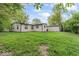 Exterior of the home with a lush green yard, mature trees and shed at 4432 Brittany Rd, Indianapolis, IN 46222