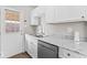 Renovated kitchen with white cabinets, stainless steel dishwasher, double basin sink, and wood-look flooring at 4432 Brittany Rd, Indianapolis, IN 46222
