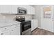 Well-lit kitchen showcasing white cabinets, granite counters, stainless steel range, and an adjacent door leading outside at 4432 Brittany Rd, Indianapolis, IN 46222