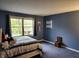 Cozy bedroom featuring blue walls, carpet, comfortable bed and window views to the beautiful outdoor scenery at 448 Tamarack Ln, Noblesville, IN 46062