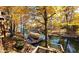 Beautiful lake view featuring a boat dock and a covered boat, with lush autumn foliage enhancing the scenery at 448 Tamarack Ln, Noblesville, IN 46062