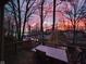 Stunning sunset over the lake with a deck in view, showcasing the property's serene and scenic waterfront location at 448 Tamarack Ln, Noblesville, IN 46062