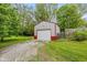 View of large detached garage, yard, and gravel driveway at 4510 Gadsden St, Indianapolis, IN 46241