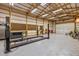 Well-lit garage featuring a four-post vehicle lift, plenty of storage space, and rolling garage door access at 4510 Gadsden St, Indianapolis, IN 46241