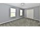 This bedroom features soft carpet, neutral walls, two windows, and sliding-door closet at 5005 Whisenand Dr, Indianapolis, IN 46254