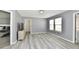 Spacious room with grey walls, two windows, hard wood floors, and a glimpse into an adjacent bedroom at 5005 Whisenand Dr, Indianapolis, IN 46254